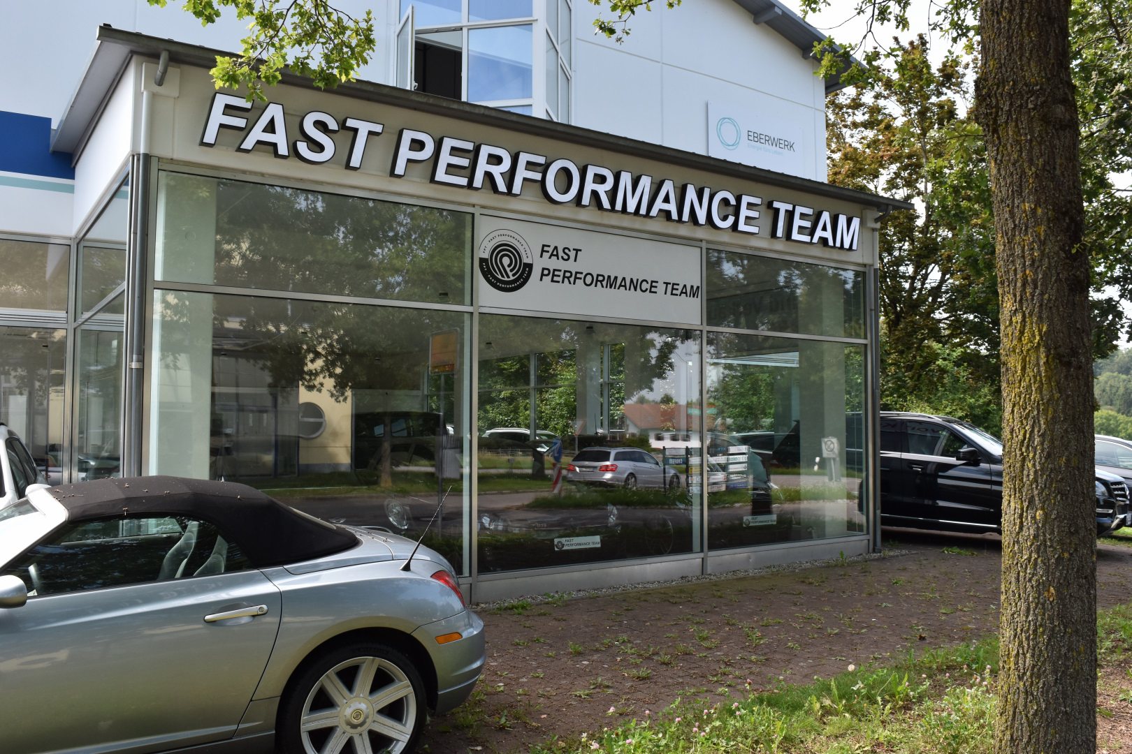Firmenschild „Fast Performance Team“ am Autohaus in Grafing